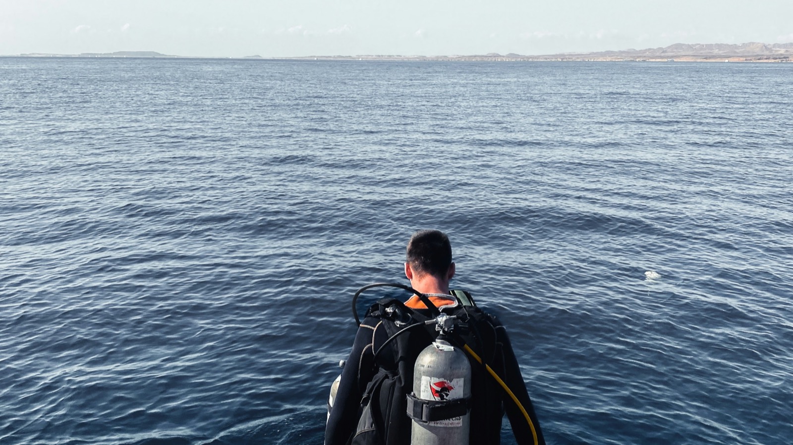 Diver stepping into the Red Sea from jetty stairs